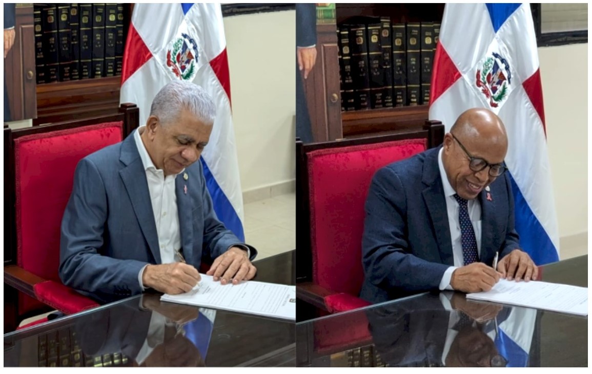 Ricardo de los Santos y Alfredo Pacheco firmando las nuevas enmiendas a la Constitución dominicana. Inter News Service