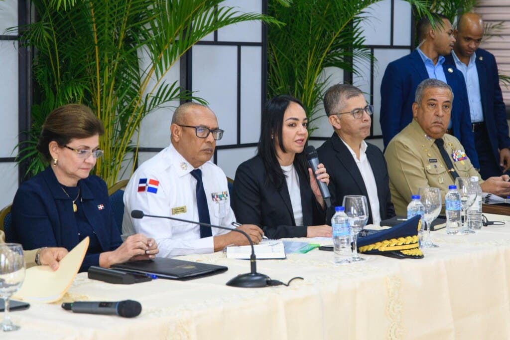 La ministra Farides Raful dando detalles sobre los homicidios. Figuran además, la vicepresidenta de la República, Raquel Peña, y otros funcionarios. (Fuente externa). Inter News Service