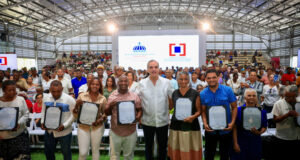 El presidente Luis Abinader junto a las familias beneficiadas con los certificados de títulos de propiedad. (Fuente Oficial). Inter News Service